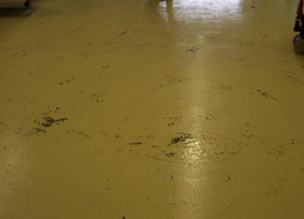 Soft spots on a factory floor appear that have darken due to dirt sticking to the tacky film.