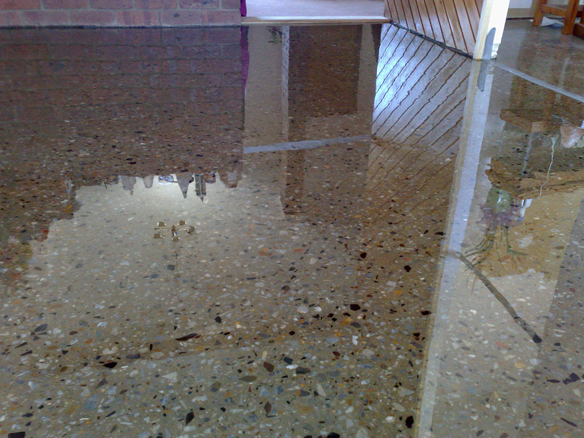 A clear epoxy resin used to create the polished concrete look in the living room of a home.