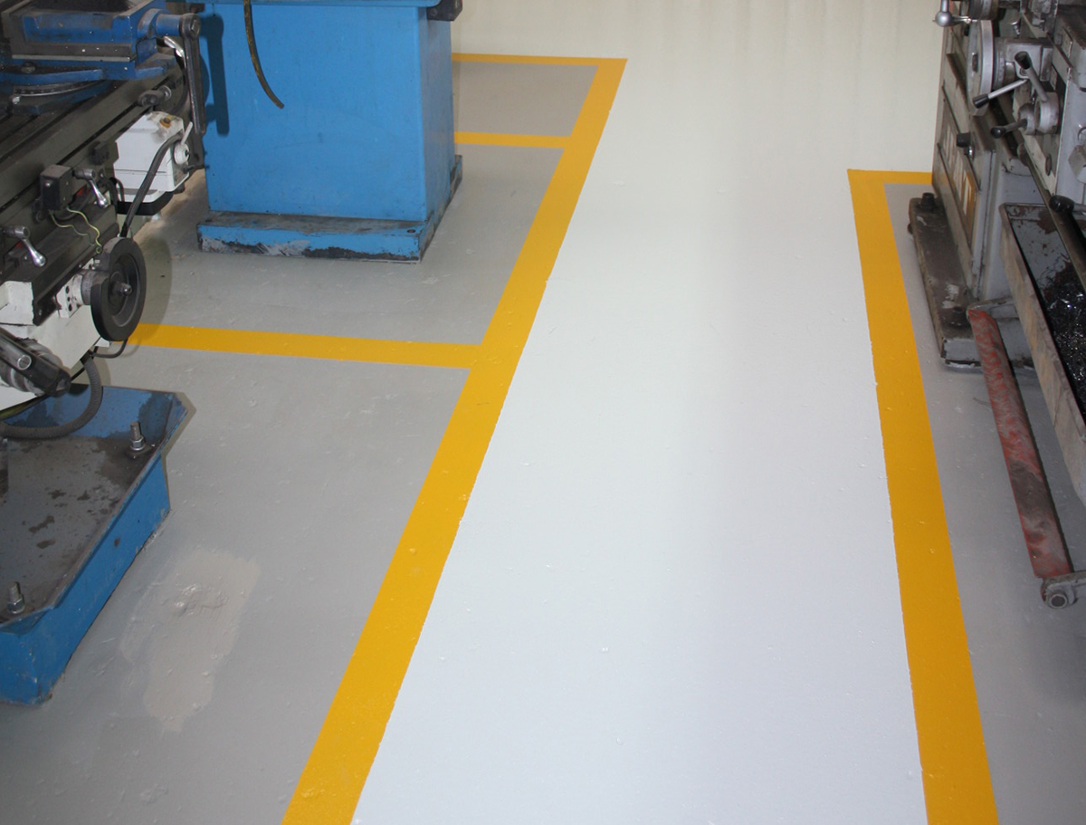 Commercial flooring example in the form of non-slip flooring and line marking in a factory.