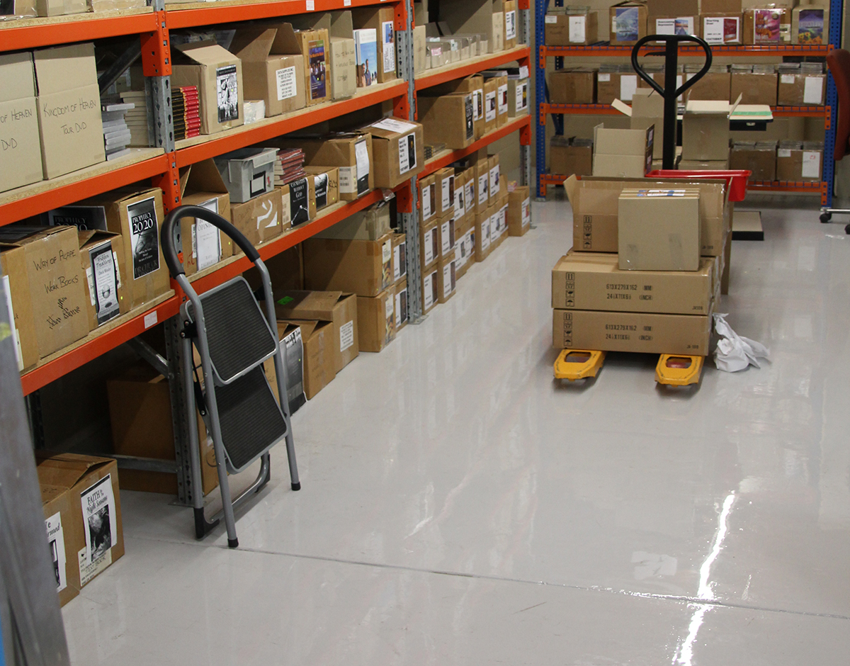 A high-gloss light grey commercial floor in the storage area of a radio broadcasting station.