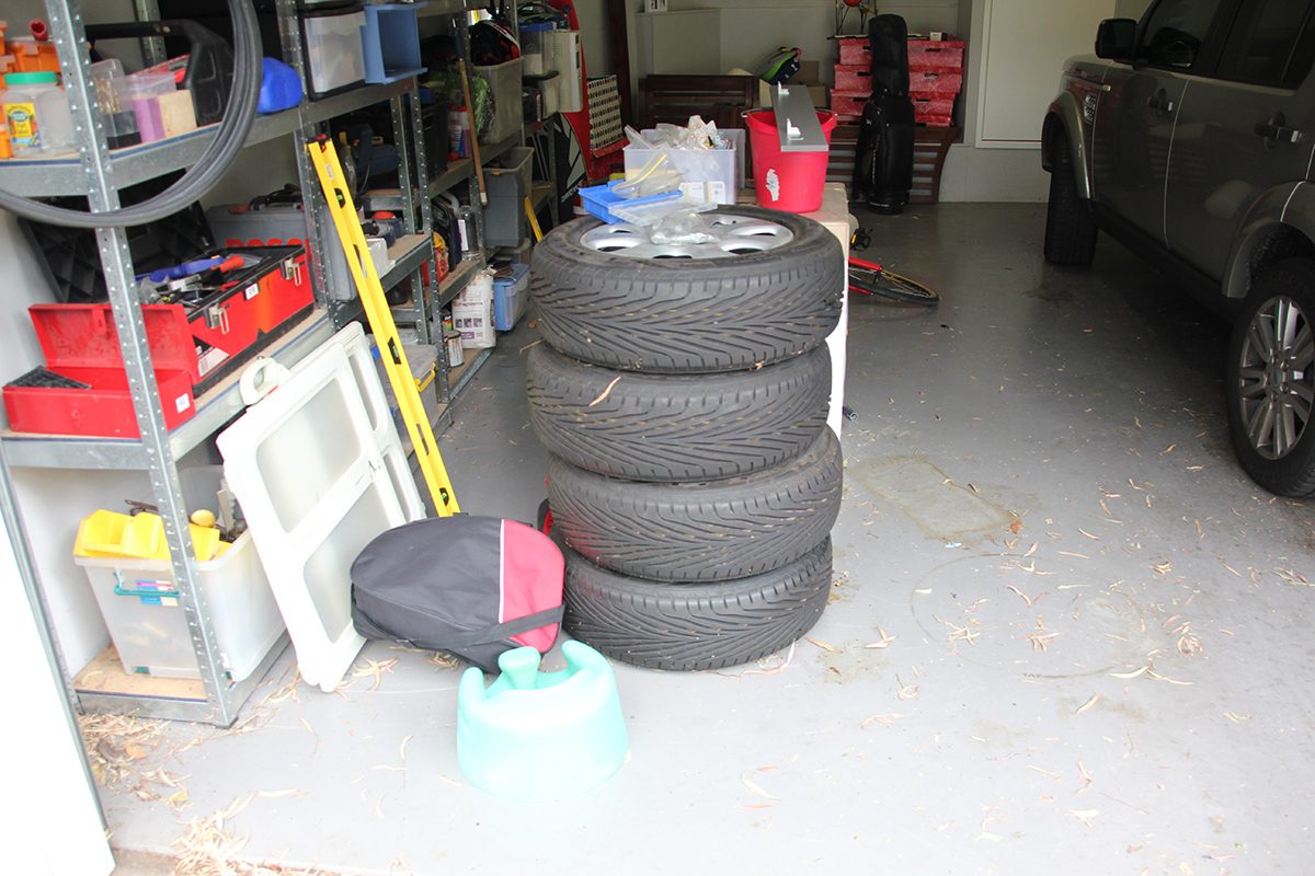 A cluttered garage floor before epoxy flooring installation.