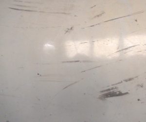 A close up of scuffing from black shoes on a glossy epoxy floors.