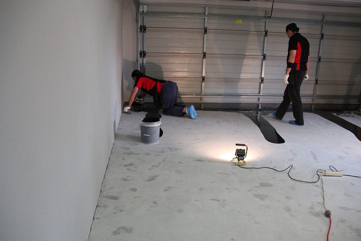 Epoxy flooring installers using low level lighting to help improve visibility of the floor.