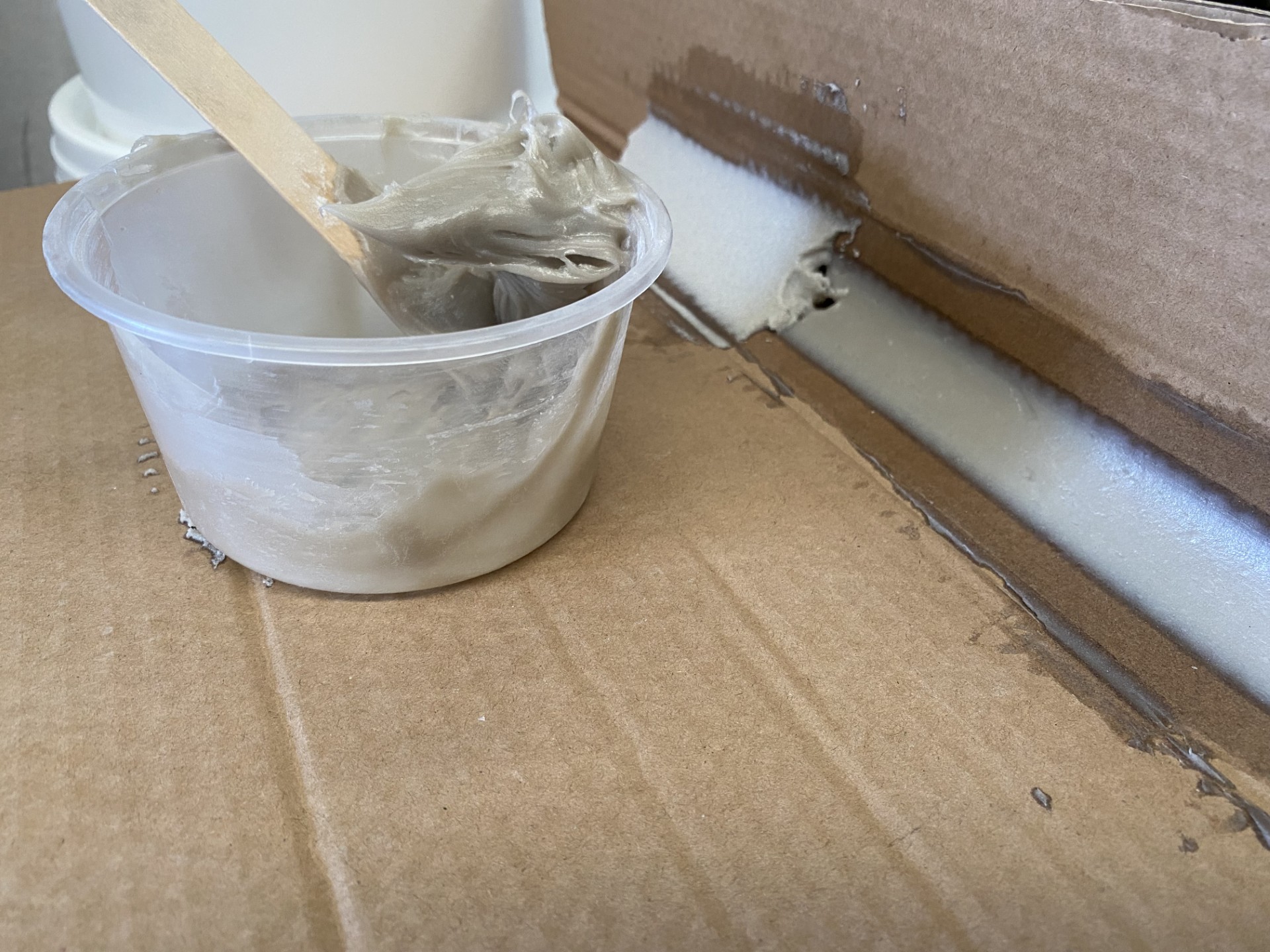 An installer on his knees trowelling down a levelling compound made from the Filler additive.