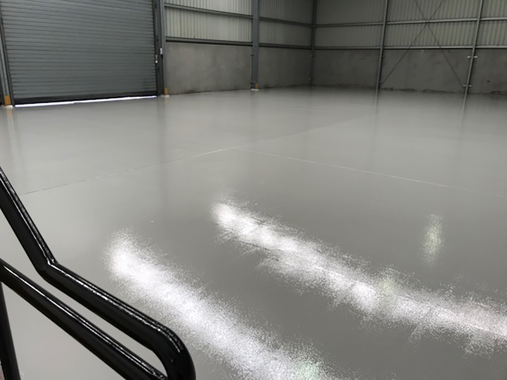 A piece of equipment sits on top of a newly applied Jaxxon floor coating in a commercial kitchen.