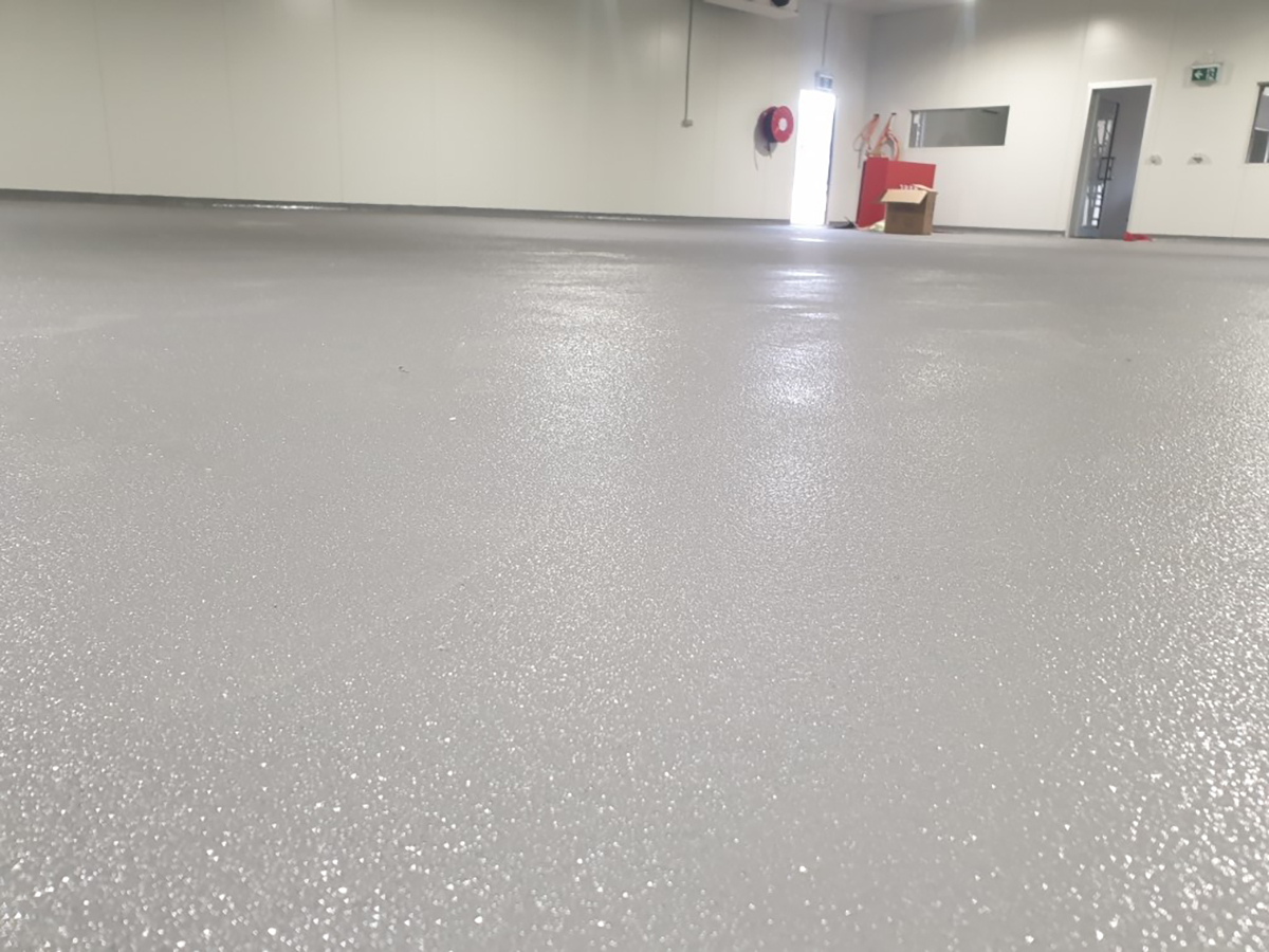 A low-angle shot of a floor in a commercial kitchen showing the texture of the non-slip finish.