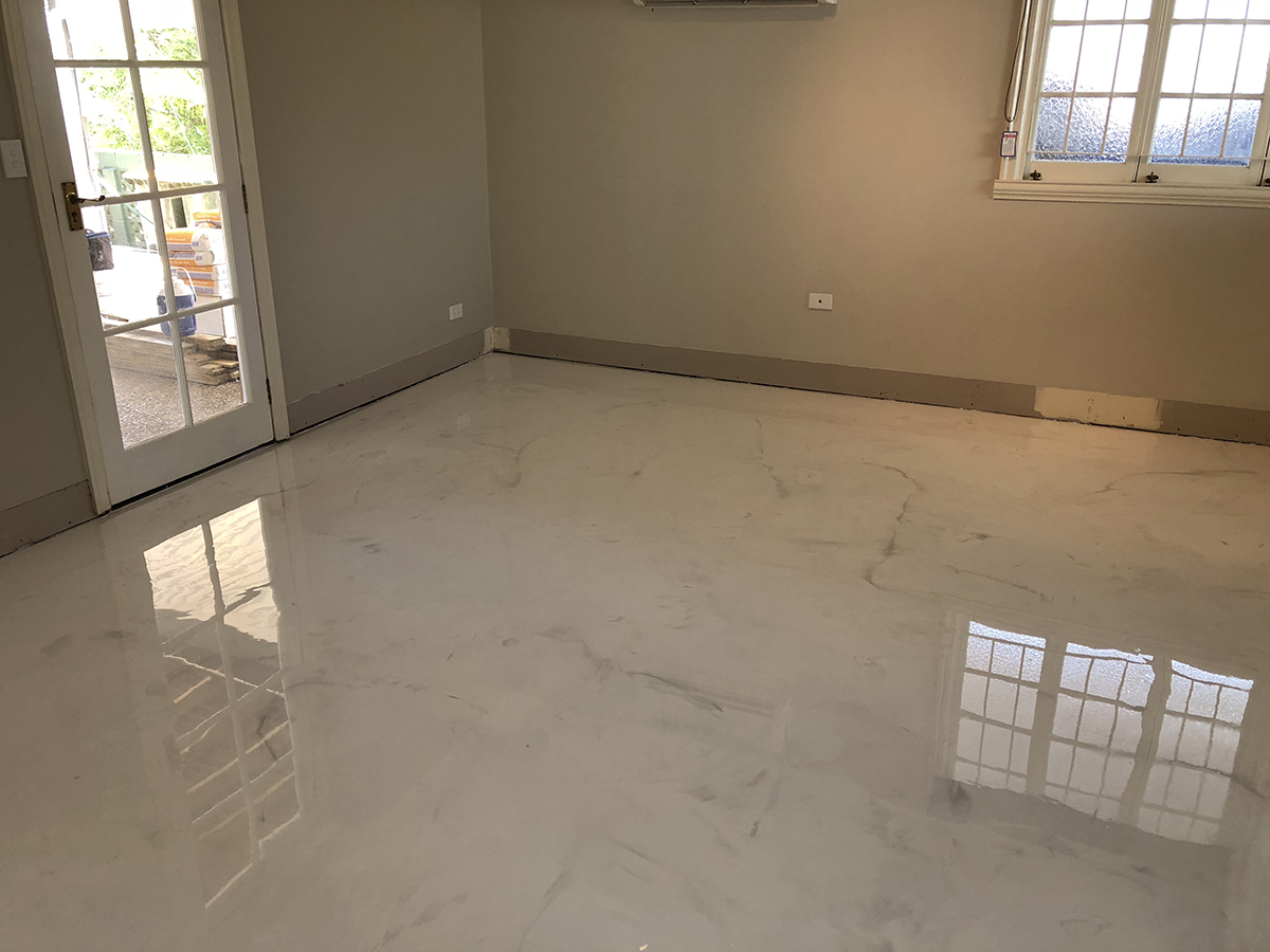 The classic white marble look was achieved on this residential bedroom floor using metallic pigments in a clear epoxy resin.