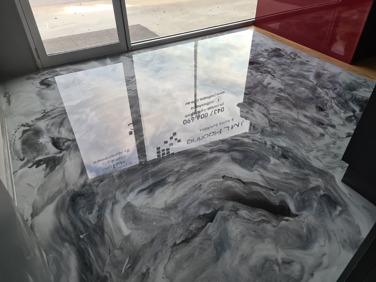 A dark, swirling grey metallic floor in an office entrance created with Artepoxy Liquid Crystal decorative epoxy resin.