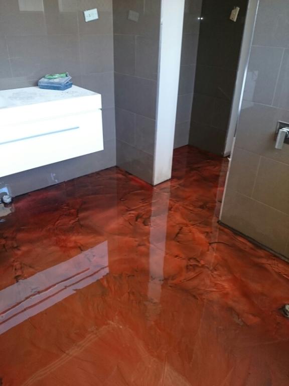 Artepoxy Liquid Crystal decorative epoxy resin was used to create a vibrant red metallic floor in a residential bathroom.