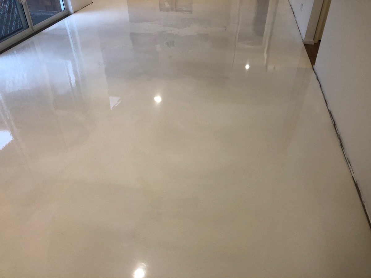 A close up of a high-gloss, white floor created through the application of Artepoxy Liquid Marble.