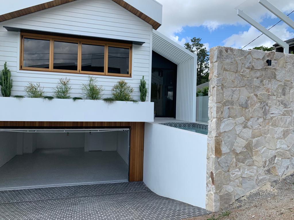 A photo taken at the top of a driveway of an open garage with new garage floor coatings applied.