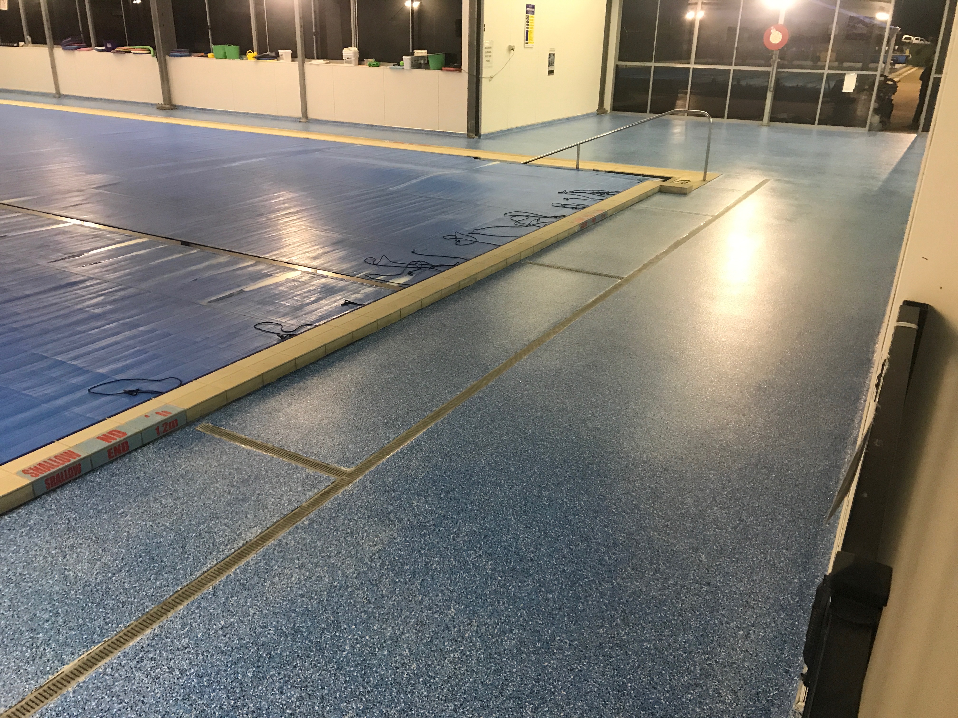 An epoxy flake floor around an indoor commercial swimming pool.