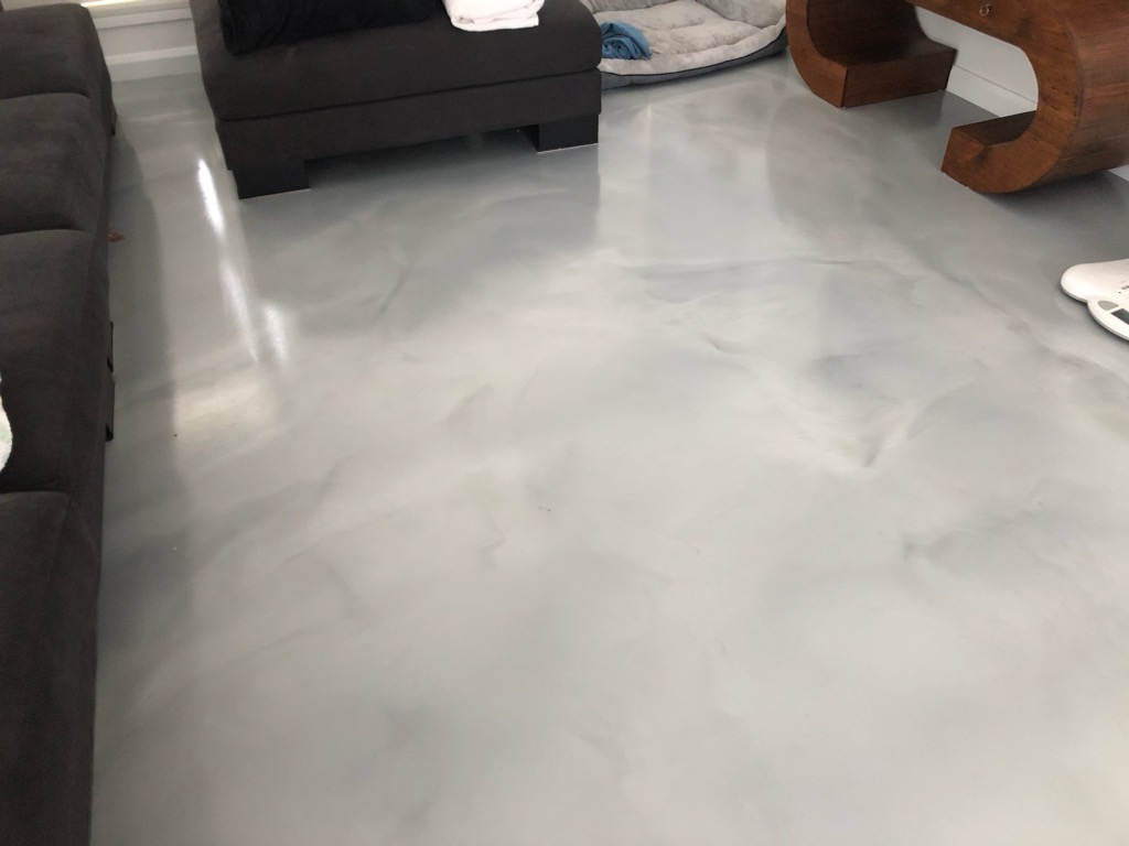 The Ezypoly polyurethane topcoat was used to reduce scratching and scuffing on a metallic floor in a modern residential living room.