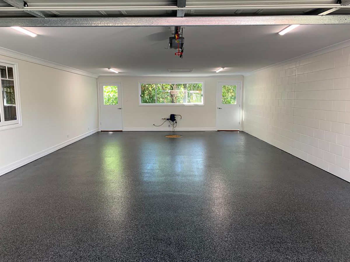 A black epoxy flake floor in an empty residential garage.