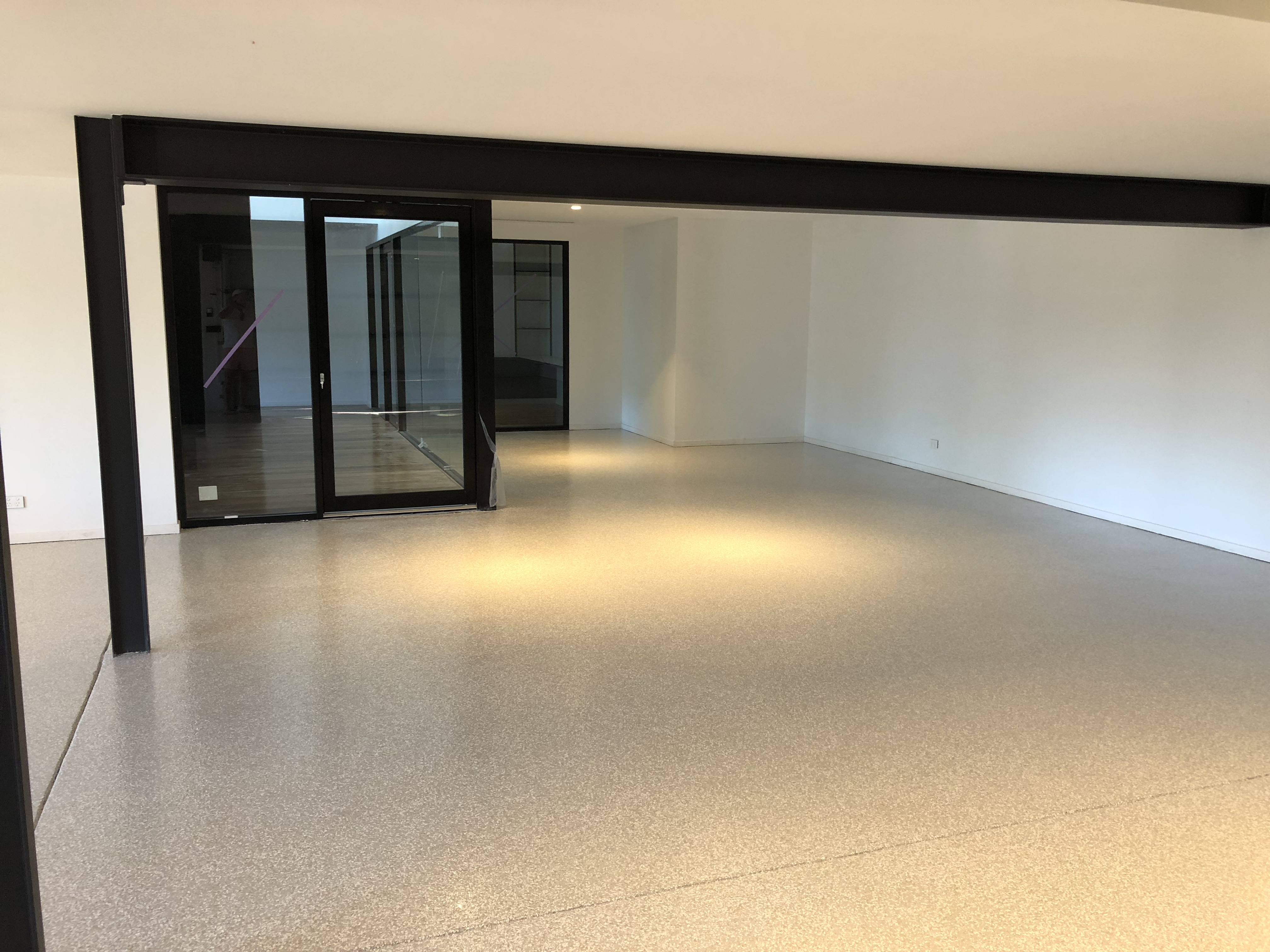 An undercover outdoor area in a home with an epoxy flake floor installed.