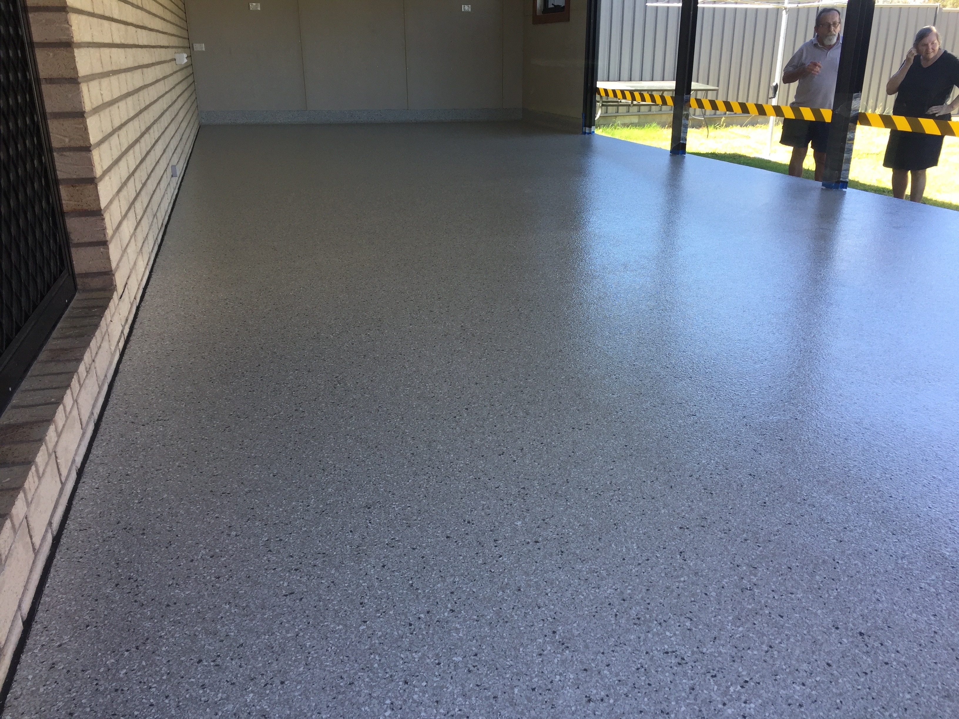A low-angle photo of a flake epoxy floor on a residential patio showing the beautiful, even finish.