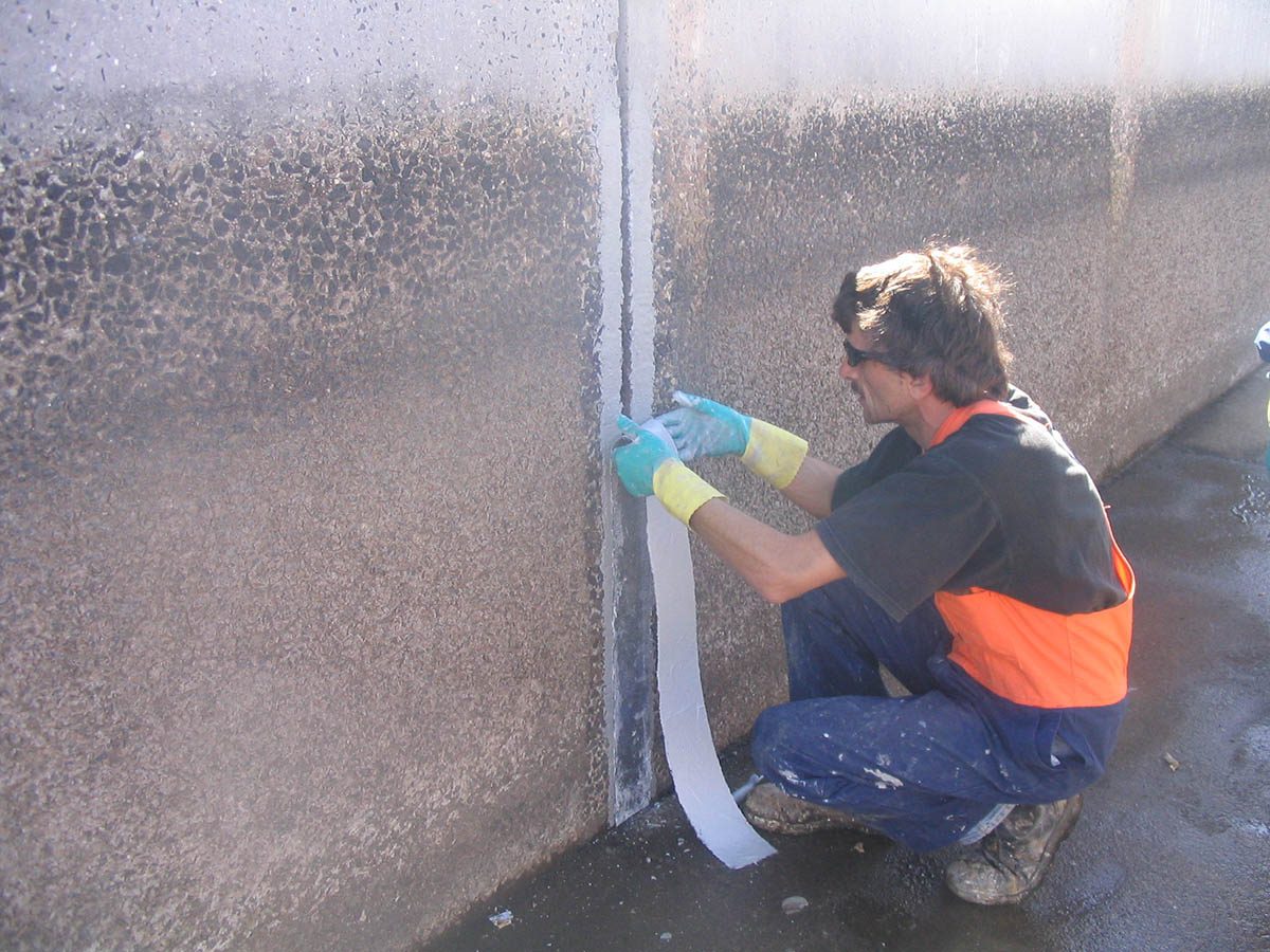 The polymer sheet with Scubapoxy 5335 being positioned onto one of the expansion joints in the flume.
