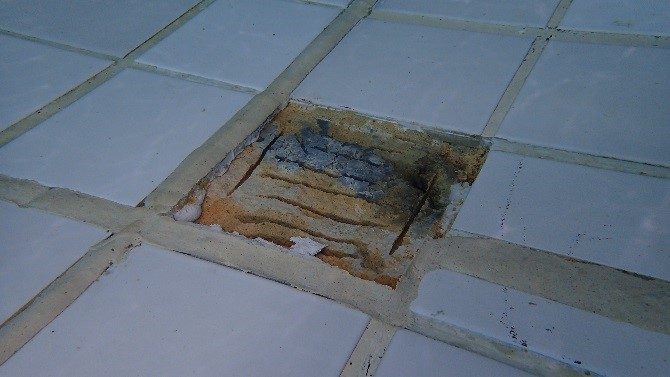 A close up of the bottom of the swimming pool after the loose tile had been removed.