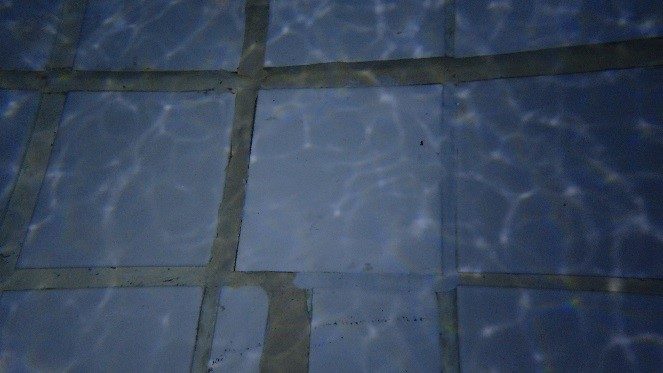 A close up of the bottom of the swimming pool after the loose tile had been replaced and re-grouted using Scubapoxy 5335.