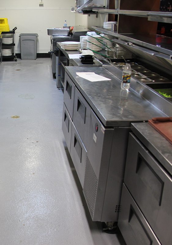 A Resin Grip floor in a commercial kitchen in need of cleaning.