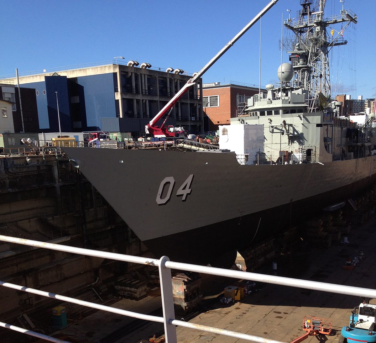 A photo of HMAS Darwin in dry dock ready for repairs and other maintenance.
