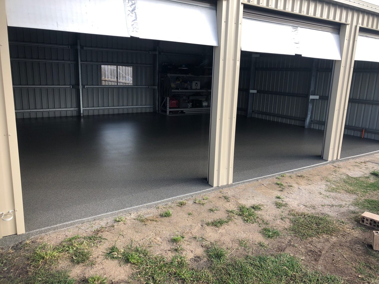 Another angle of the front of the residential garage with doors open, showing the new epoxy flake floor inside.
