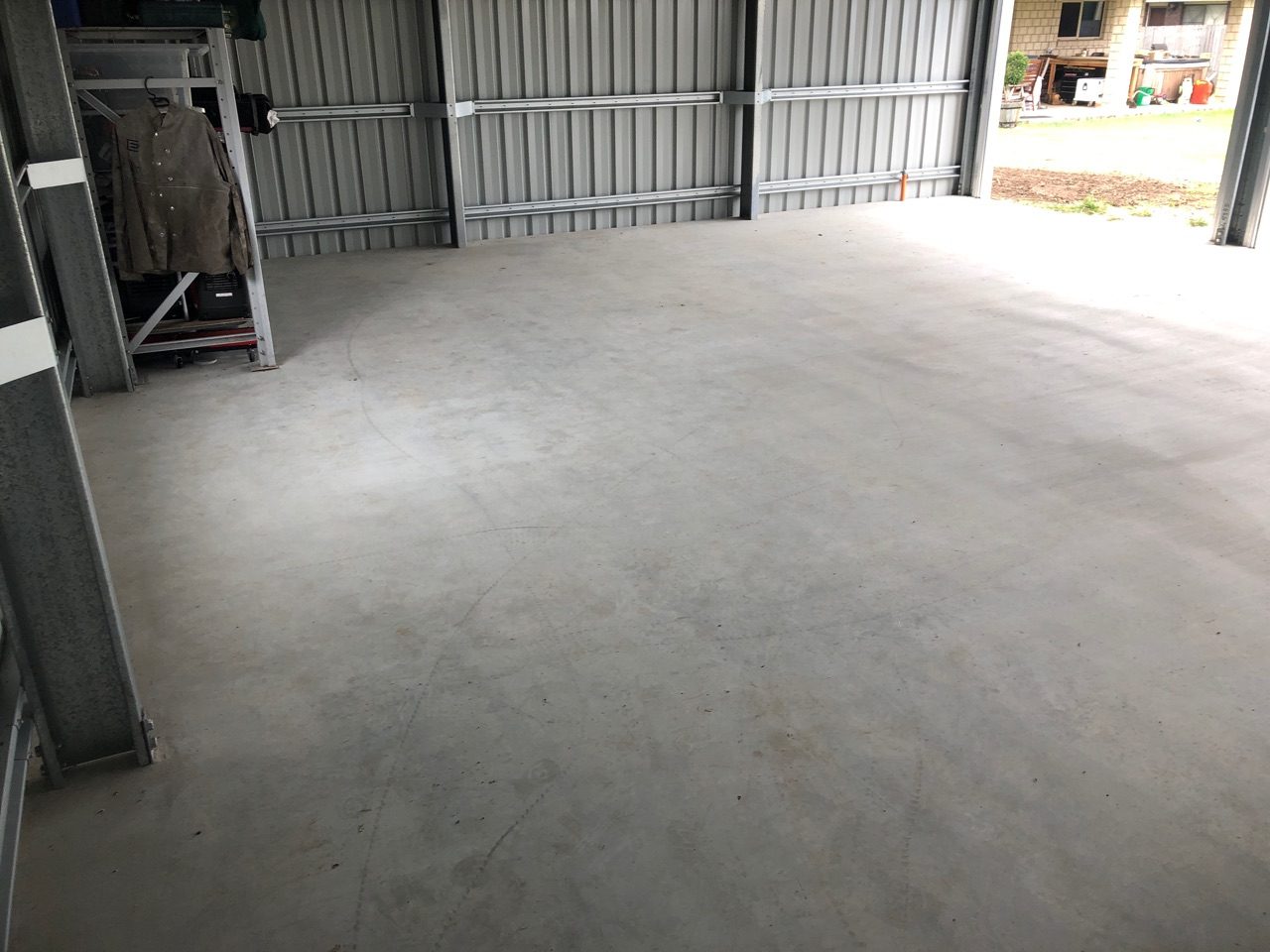 A photo taken before the project from the back of the residential garage with the original concrete slab visible.