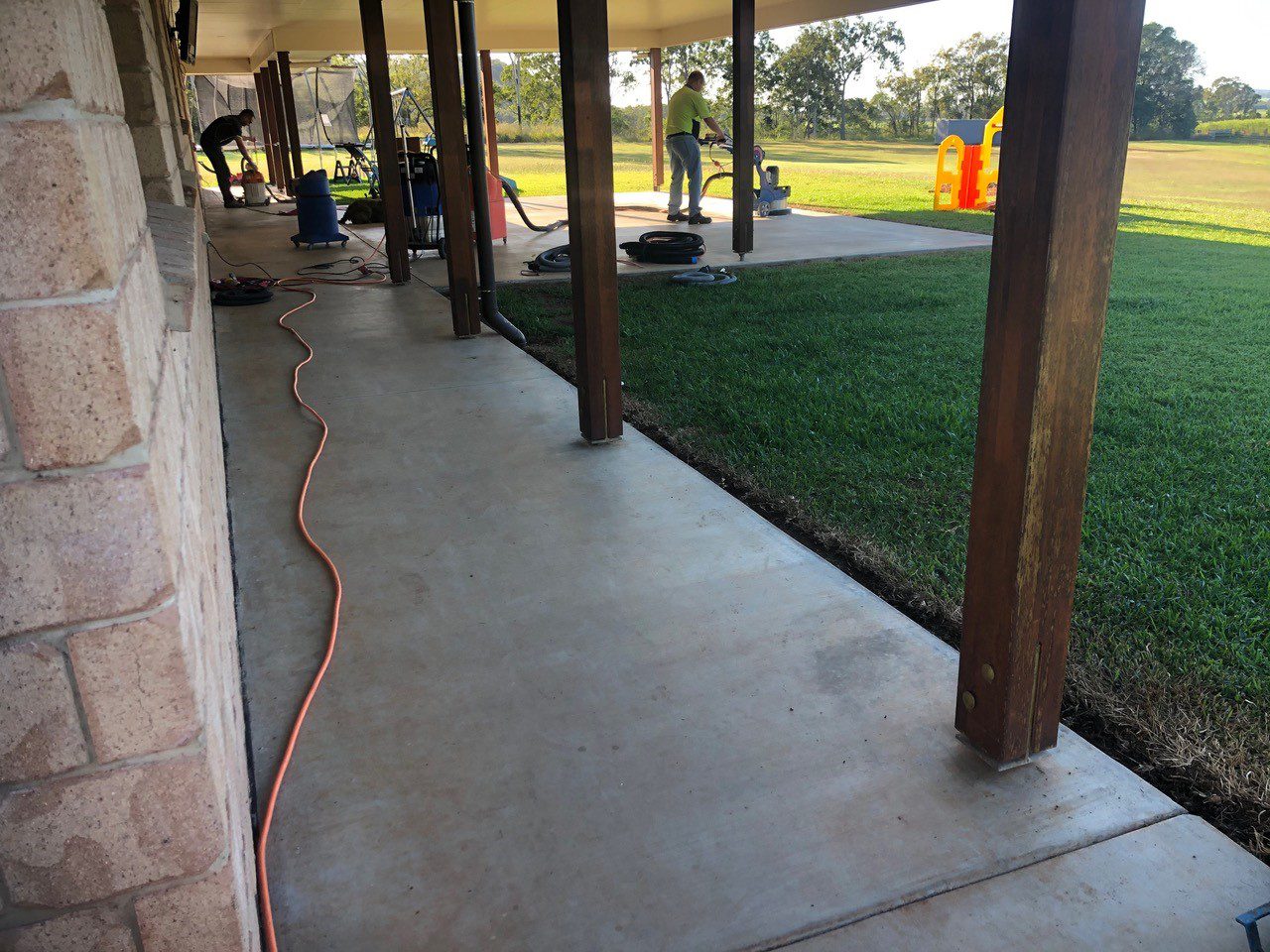 A photo taken during surface preparation from the side of the residential patio with the original concrete slab visible.