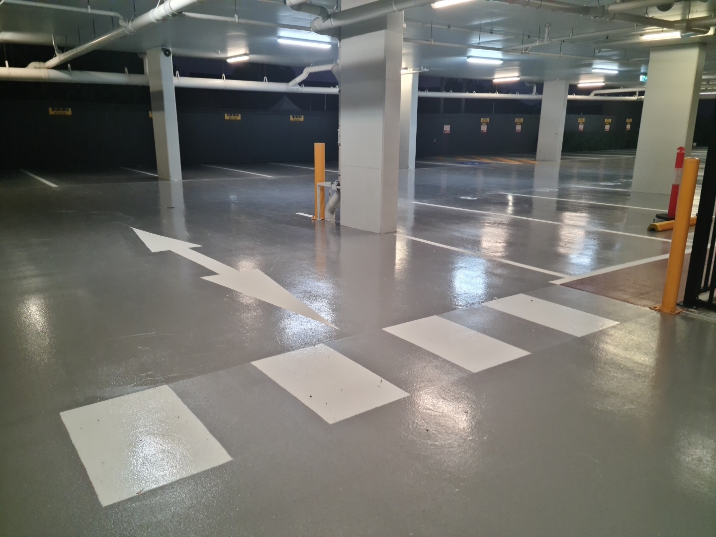 A view from inside the empty warehouse looking back towards the entrance with the new protective epoxy floor in the foreground.
