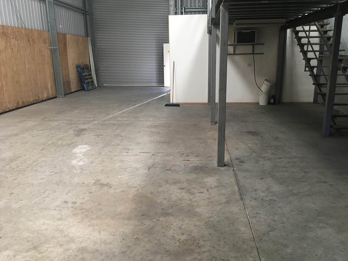 A photo taken before the project from the back of the warehouse with the original, contaminated concrete slab visible.