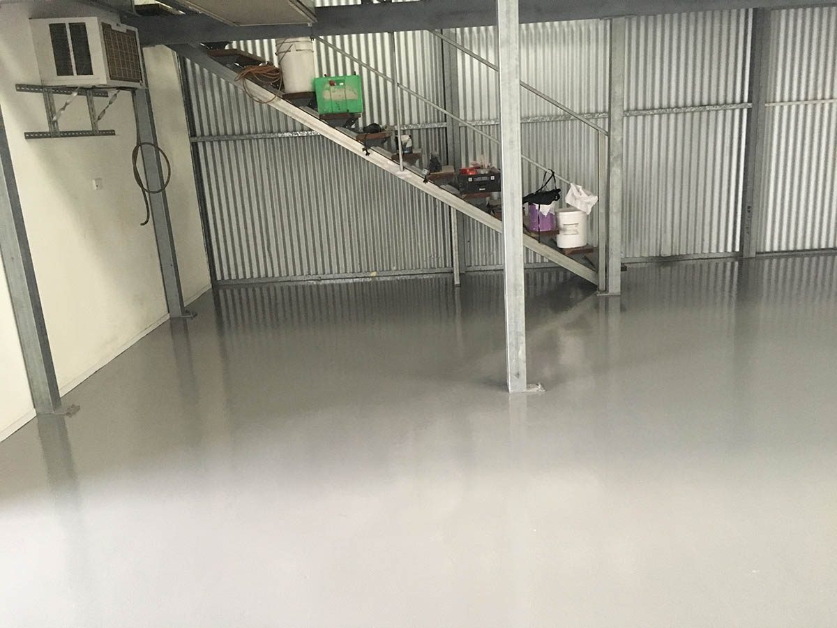 Another angle of the new protective epoxy floor showing how it brightened the previously dark area behind the office and underneath the mezzanine stairs.