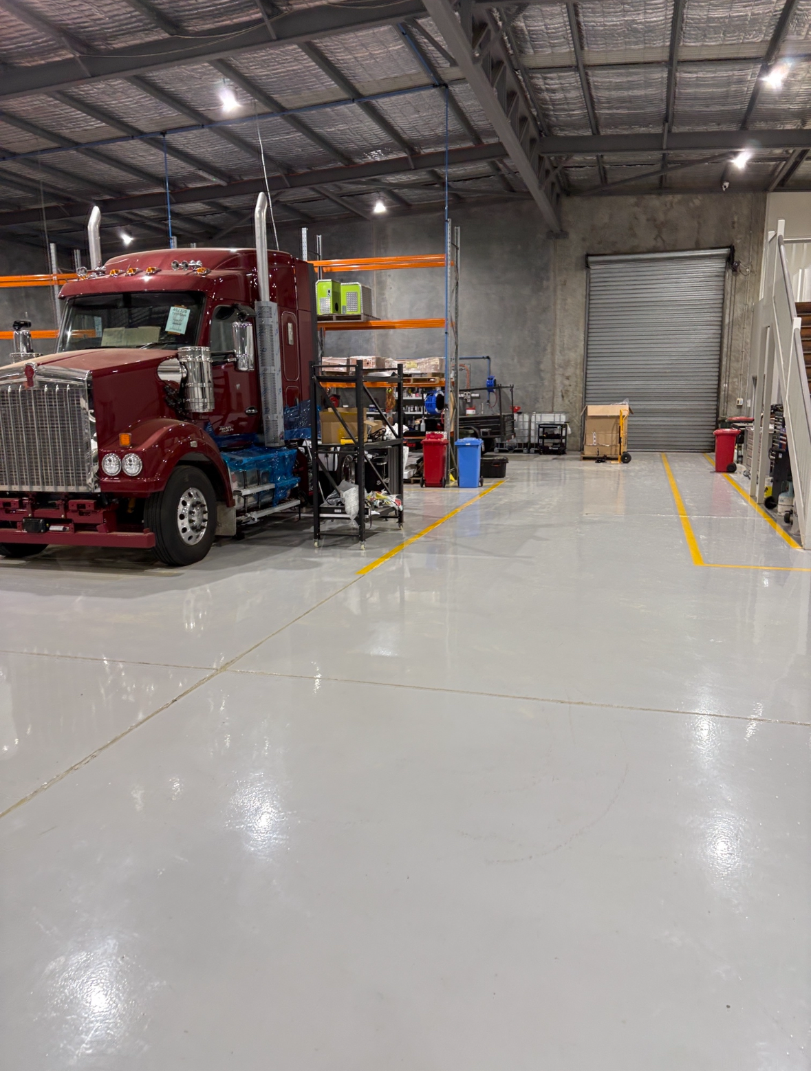 A view of the empty warehouse from the open front door showing the new protective epoxy floor covering the large area.