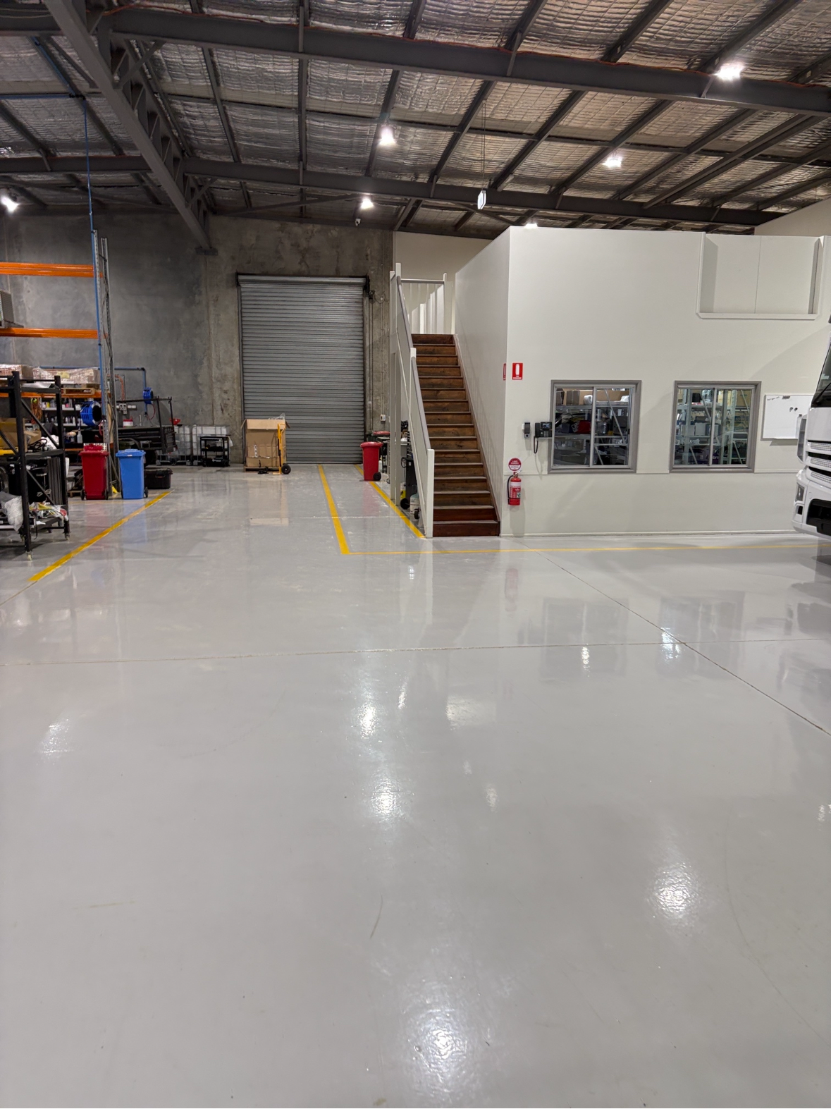 A view from inside the empty warehouse looking back towards the entrance with the new protective epoxy floor in the foreground.