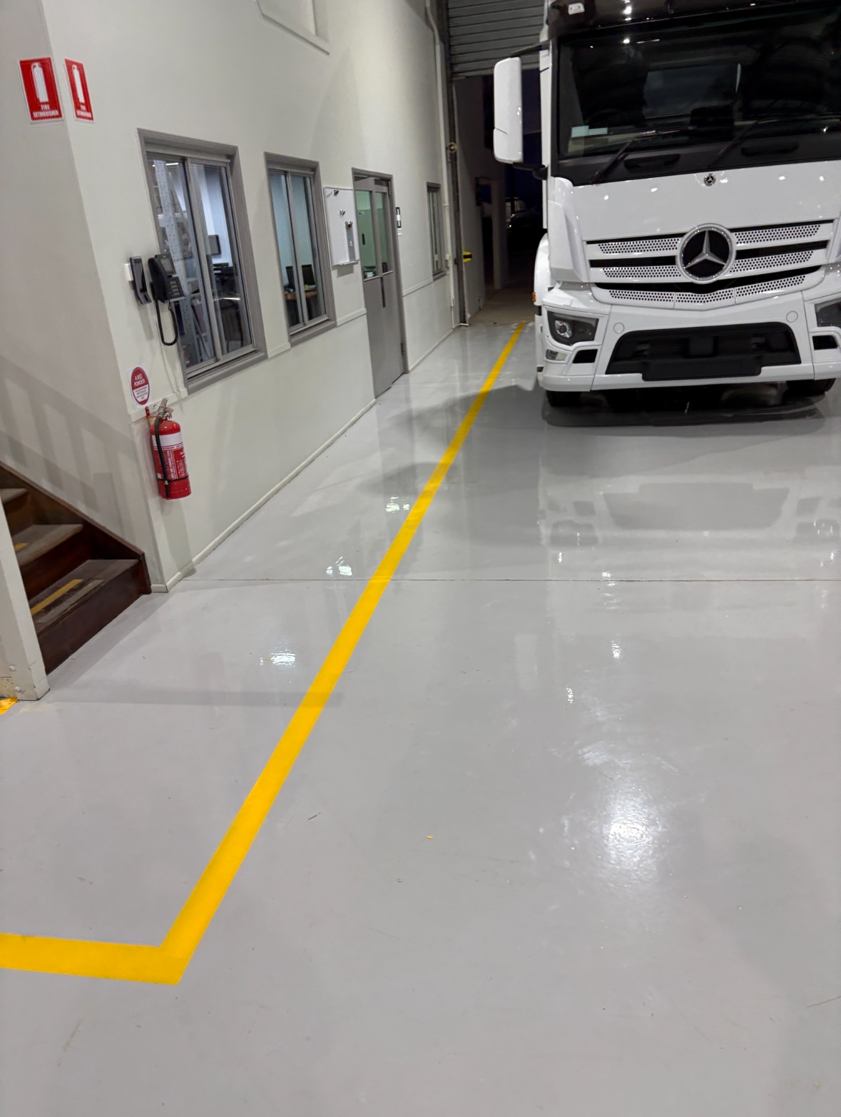 A view from inside the empty warehouse looking back towards the entrance with the new protective epoxy floor in the foreground.