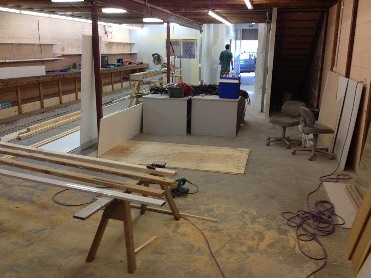 A photo taken before the project of the building being renovated with lots of wood and machinery cluttering the floor.