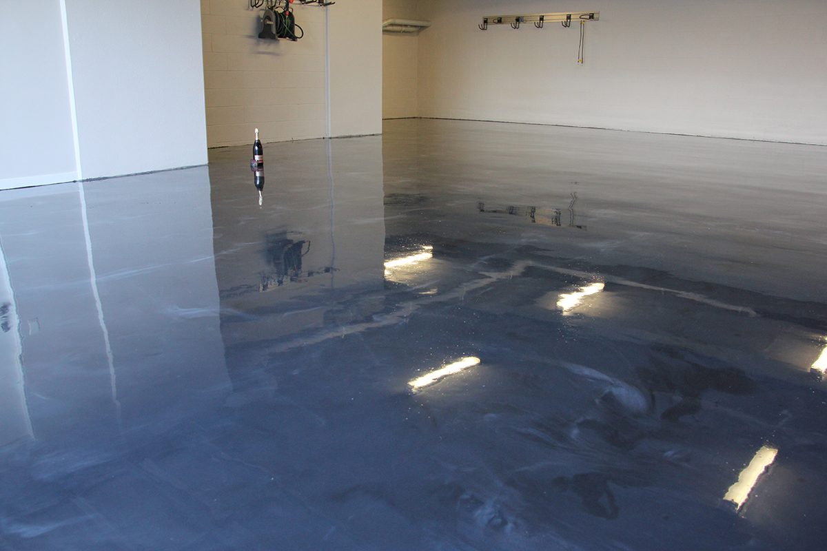 A low-angle photo of the garage from the front looking across the high-gloss metallic epoxy floor that had just been installed.