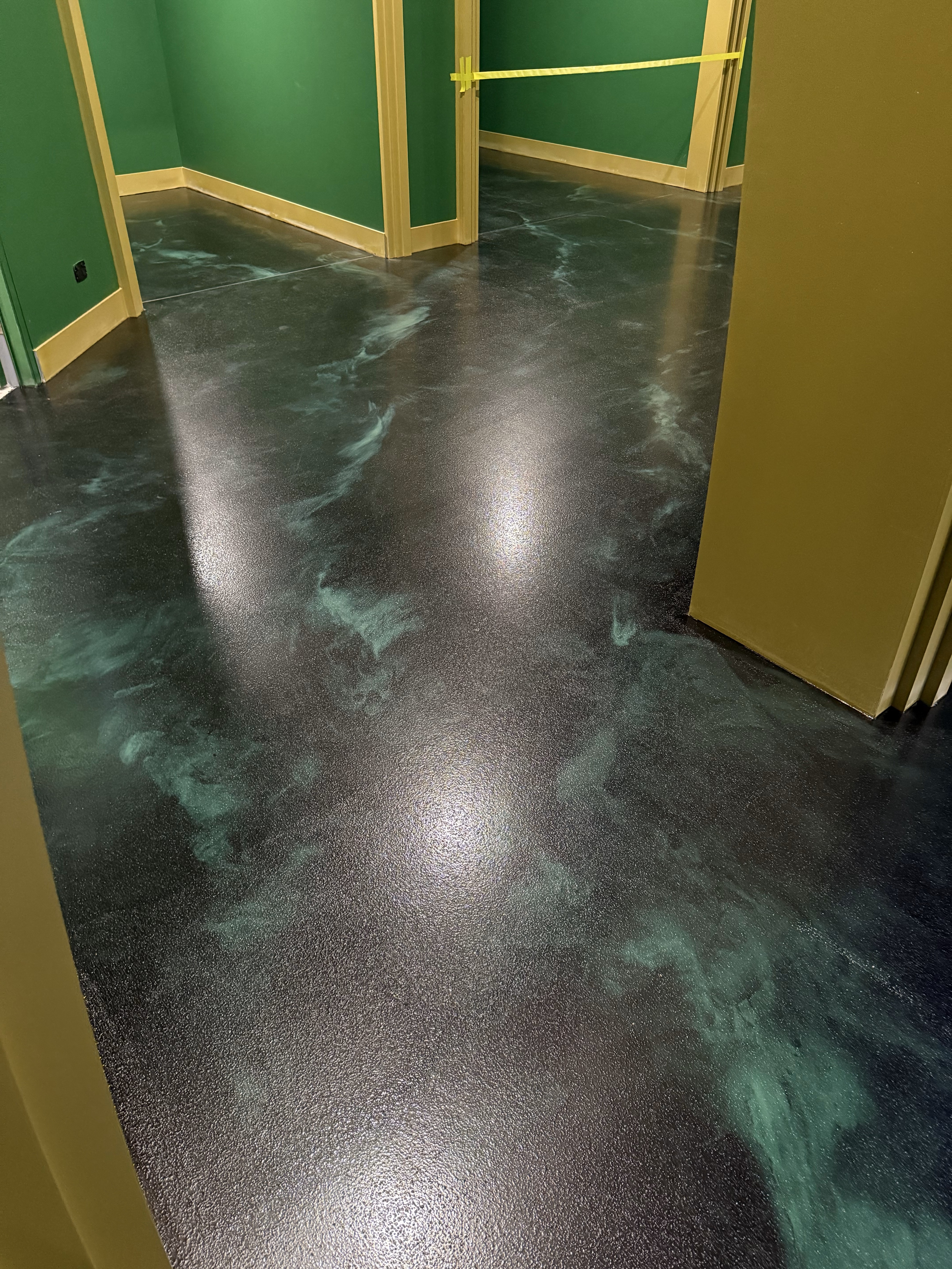 A photo taken from the back of the cafe looking towards the entrance, showing the clean, modern look the new silver metallic epoxy floor provided.