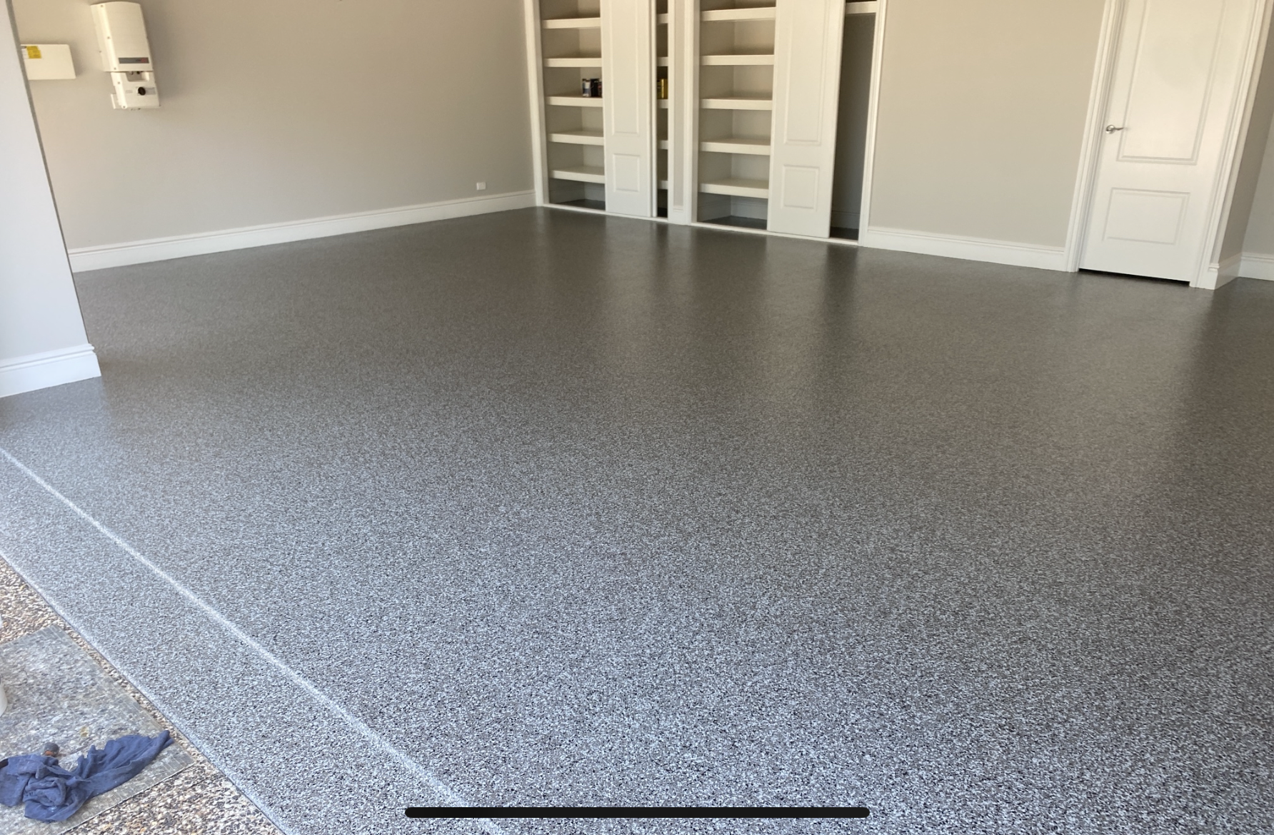 A photo taken before the project from the front of the residential garage with the original, oil-stained concrete slab visible.