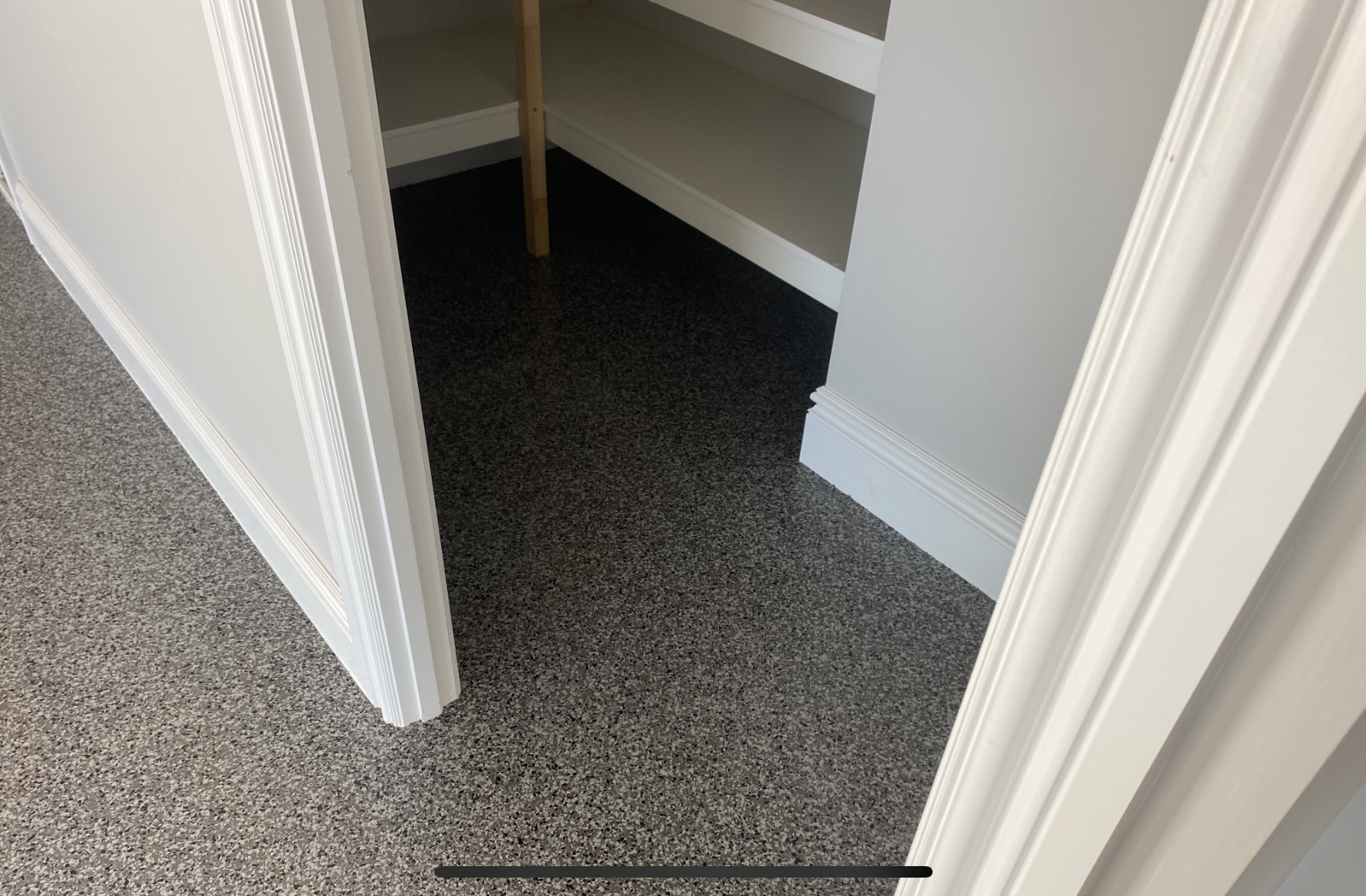 The front of the residential garage with doors open, showing the new epoxy flake floor with car parked on top of it.