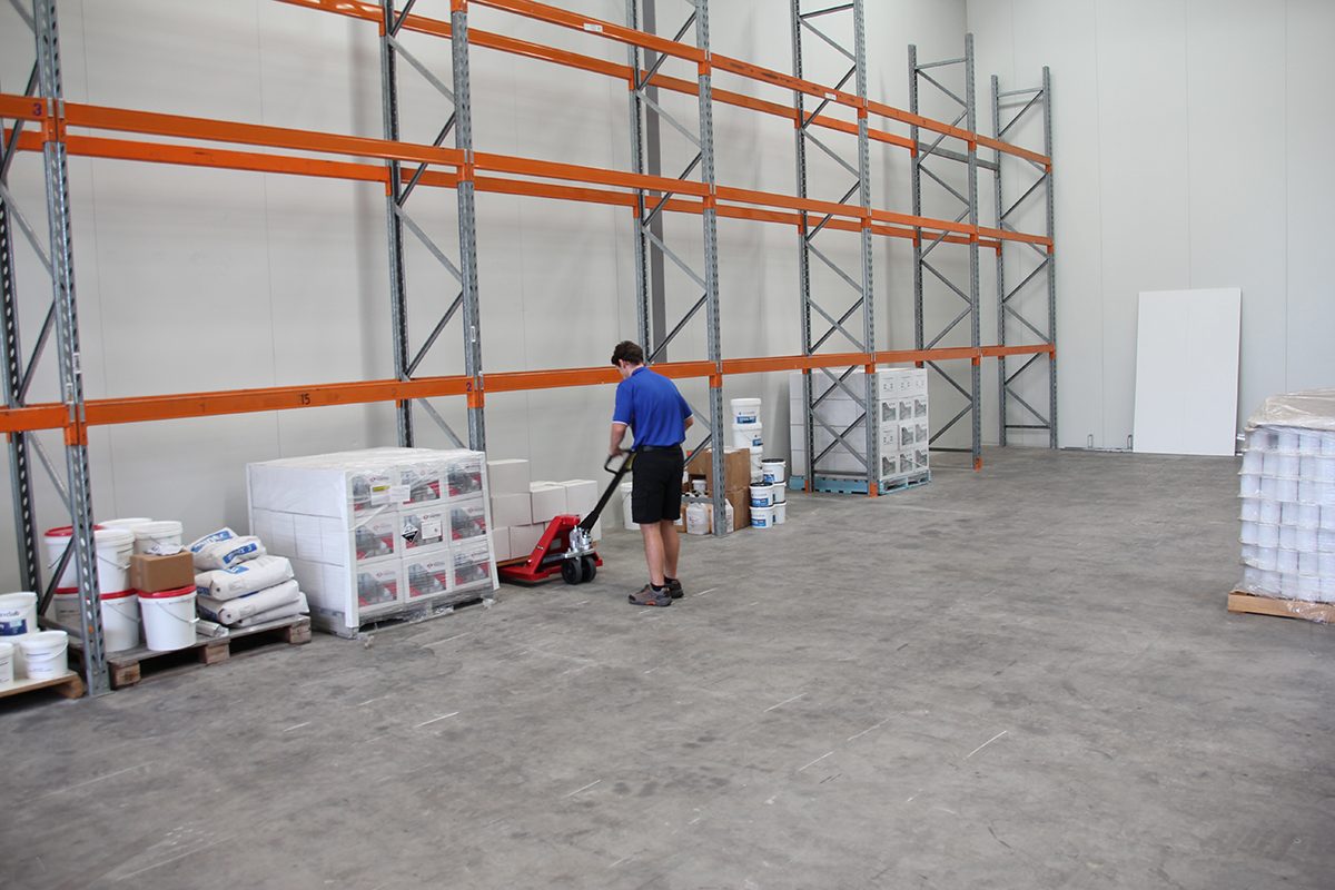 An epoxy flooring manufacturer moving stock around in a warehouse that's almost empty.
